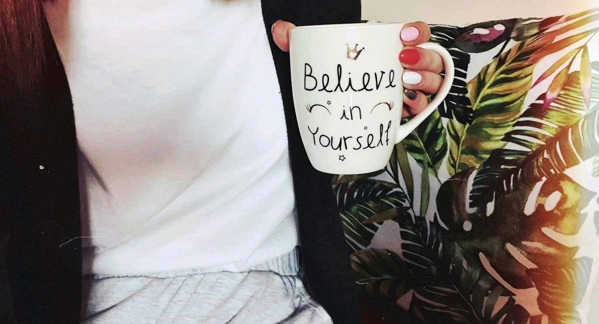 woman wearing black cardigan holding mug