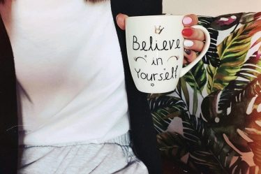 woman wearing black cardigan holding mug